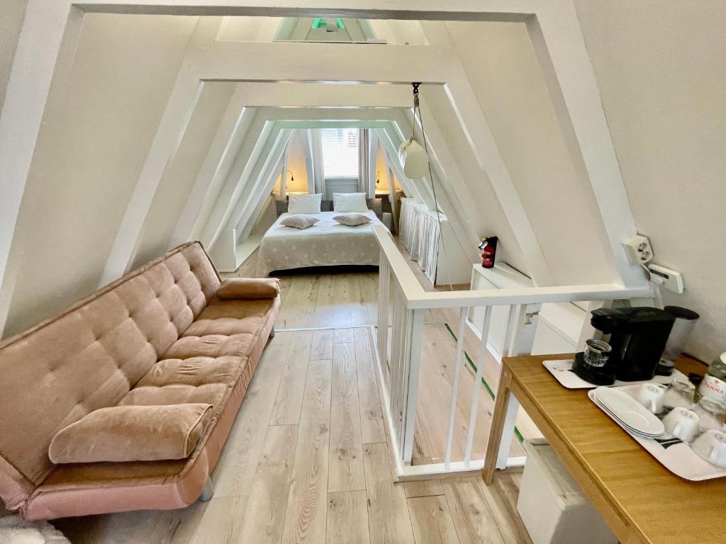 Olive Bed and Breakfast في أمستردام: غرفة معيشة مع أريكة وسرير