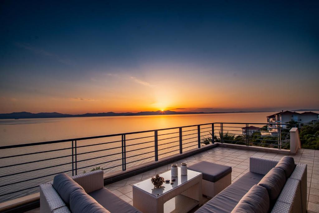 a view of a sunset from the deck of a house at Sea Whisper Villa in Peloponnese in rkadiko Chorio