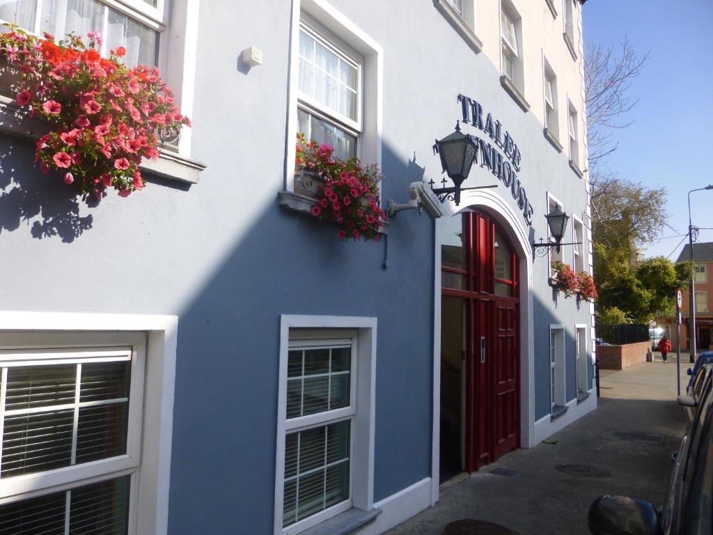 ein blau-weißes Gebäude mit einer roten Tür und Blumen in der Unterkunft Tralee Townhouse in Tralee