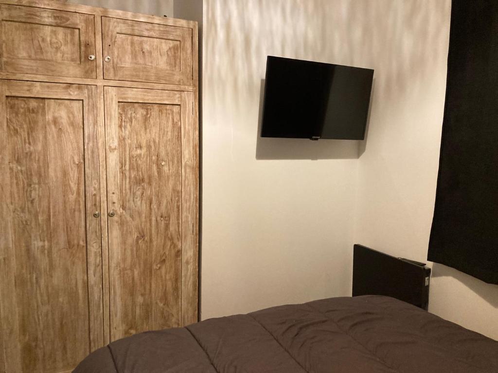sypialnia z łóżkiem i telewizorem z płaskim ekranem w obiekcie Chez Marie-Pierre w mieście Les Angles