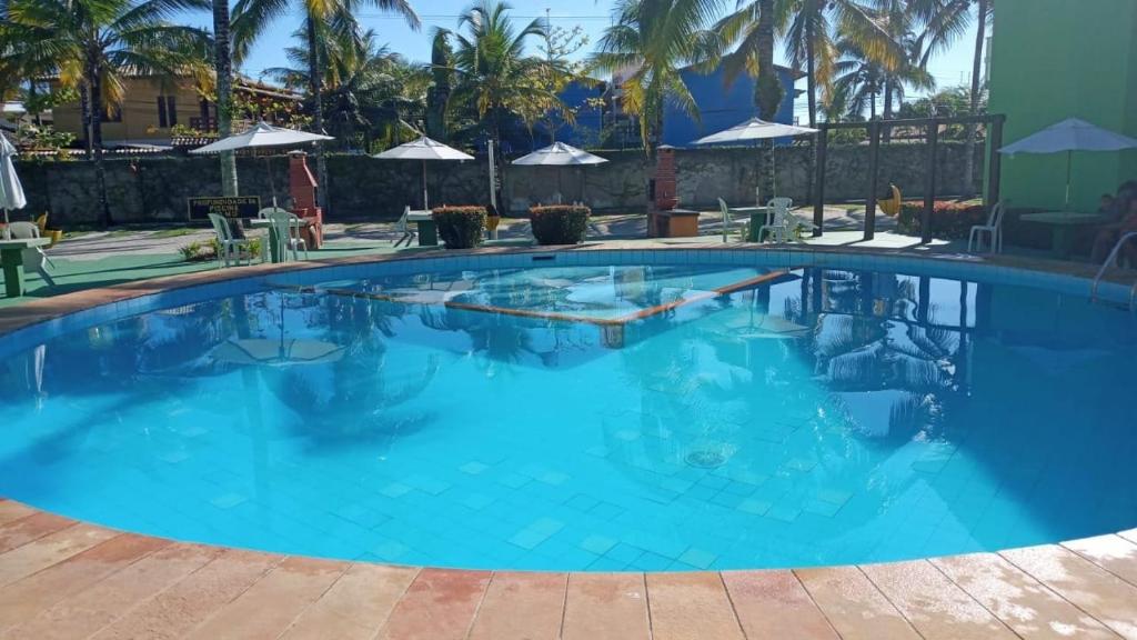 a large swimming pool with blue water at JL Temporadas - Apto Village Taperapuan in Porto Seguro