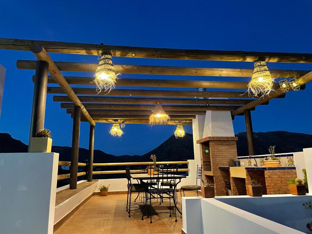 une terrasse avec des lumières, une table et des chaises dans l'établissement VILLA CARMEN, à Níjar