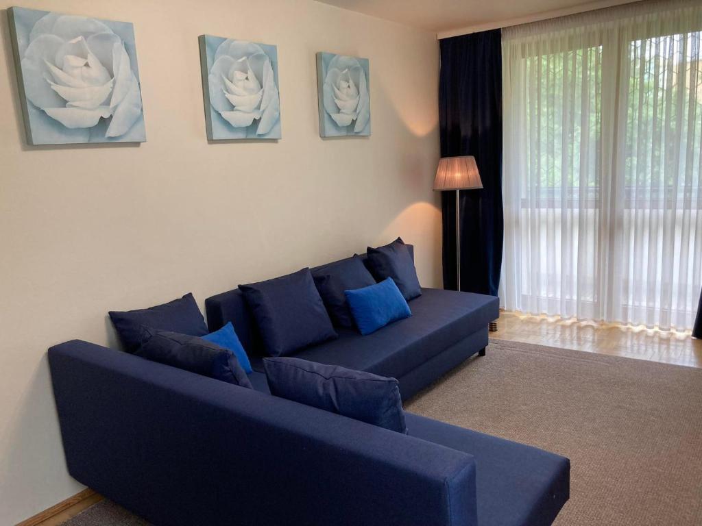 salon z niebieską kanapą i niebieskimi poduszkami w obiekcie Wzgórze Czwartek w mieście Lublin