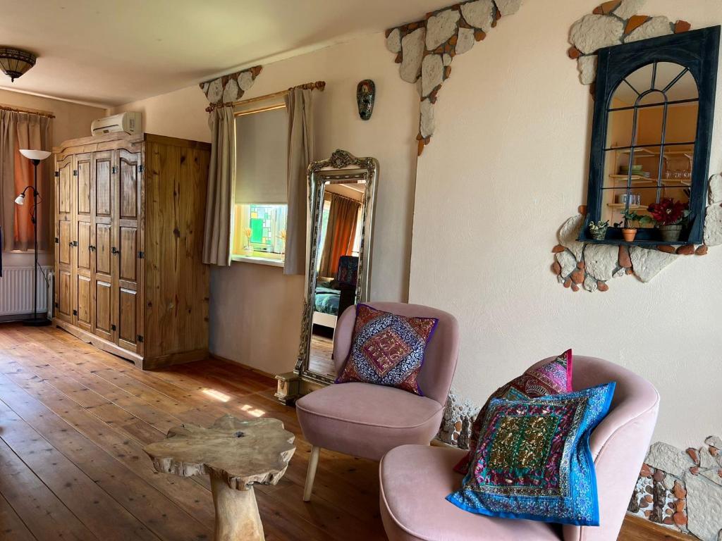 een woonkamer met 2 stoelen en een spiegel bij La Cabaña in Zandvoort