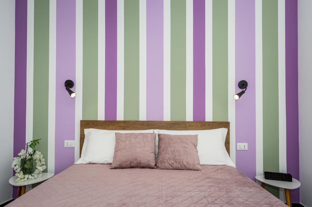 a bedroom with a bed and a striped wall at A lu Puzziddu in Castellammare del Golfo