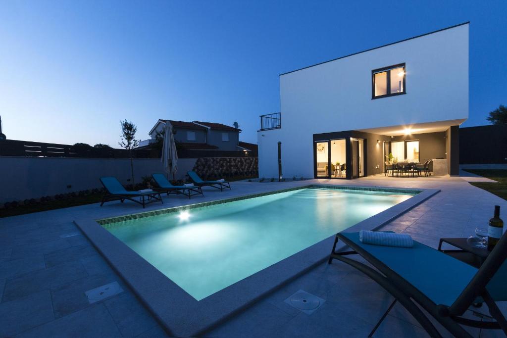 a swimming pool in the backyard of a house at night at Modern 3-bedroom villa with a private pool in Pula