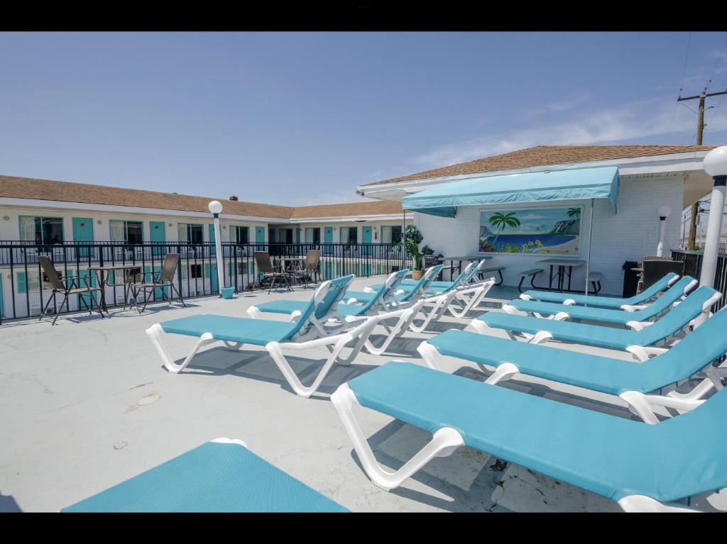a group of blue and white lounge chairs on a patio at Surfcomber Motel in Wildwood