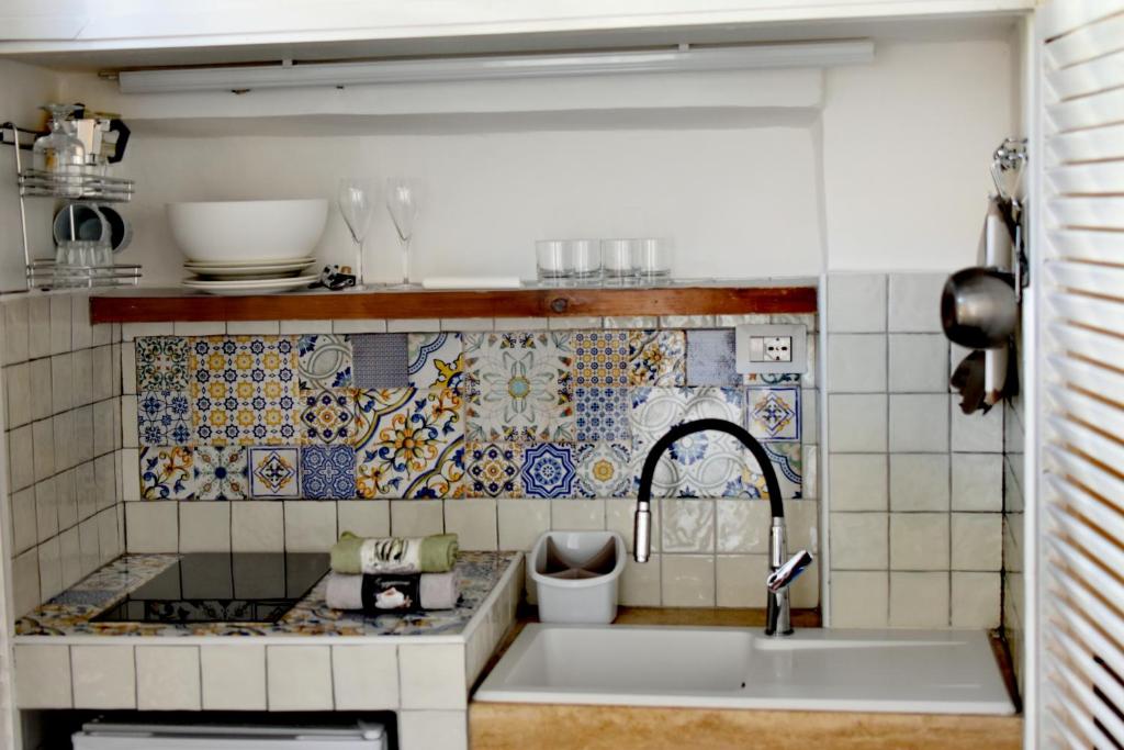 a kitchen with a sink and a tile wall at Tiny Circe house - alloggio turistico in San Felice Circeo