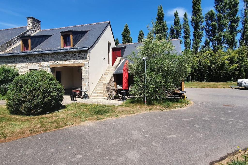 a house with a red item on the side of it at Tout le confort au milieu d'un parc botanique in Noyal-Muzillac