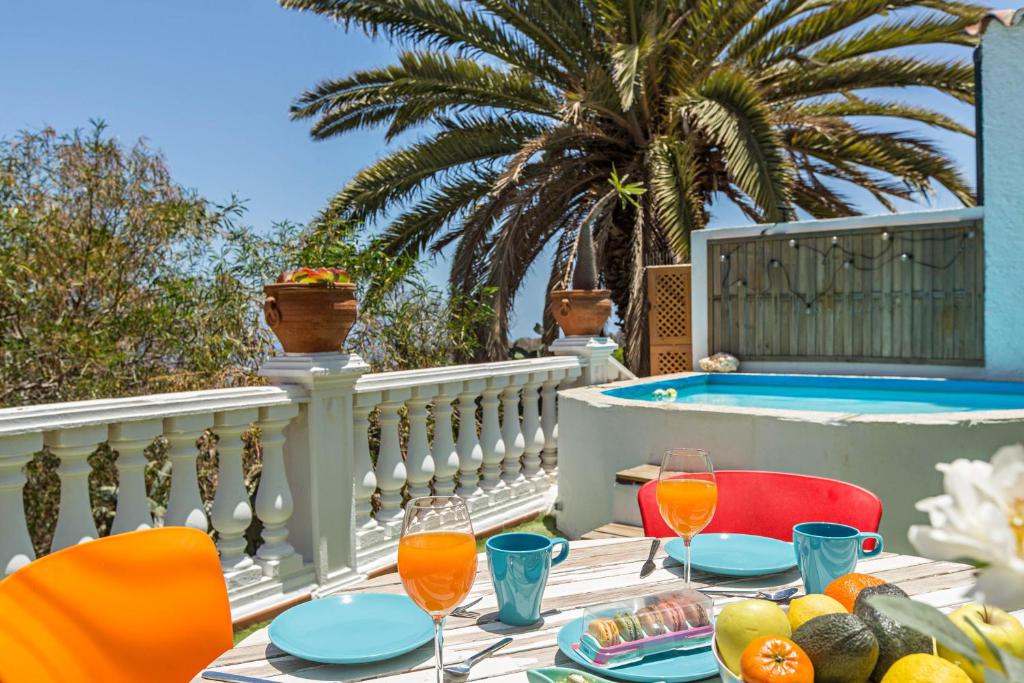 uma mesa com comida e bebidas numa varanda com piscina em Villa Frida Kahlo em Telde
