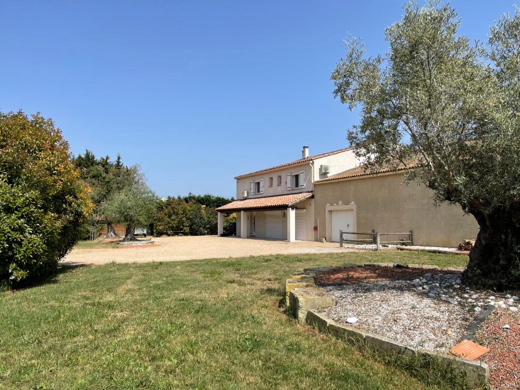 a building with a tree in the yard at Appartements calmes LE MAS DE LAURIANE in Saintes-Maries-de-la-Mer