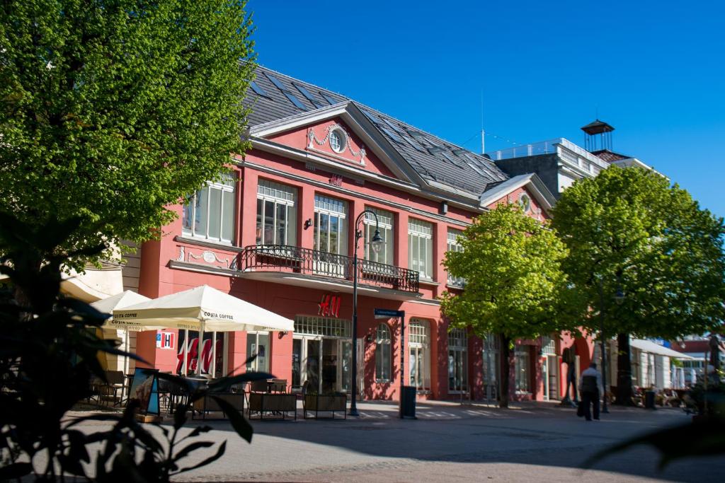 czerwony budynek na ulicy w mieście w obiekcie Monciak55 Sopot Apartments w mieście Sopot