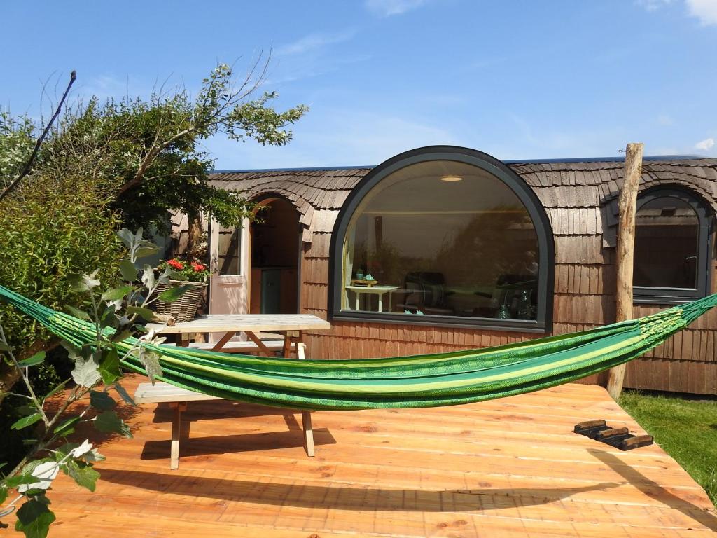 een hangmat op een terras voor een huis bij De Hut, in Natuurgebied en vlakbij het Strand in Callantsoog