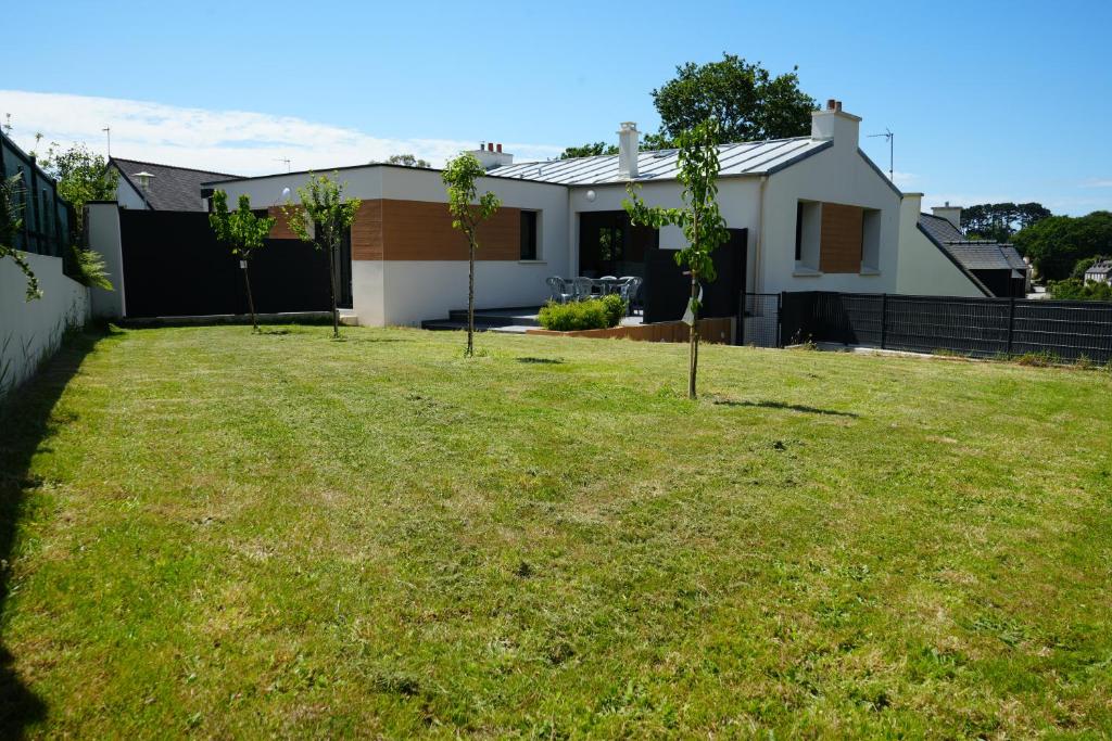 Una casa con un patio con dos árboles. en Maison contemporaine aux portes de Brest en Bohars