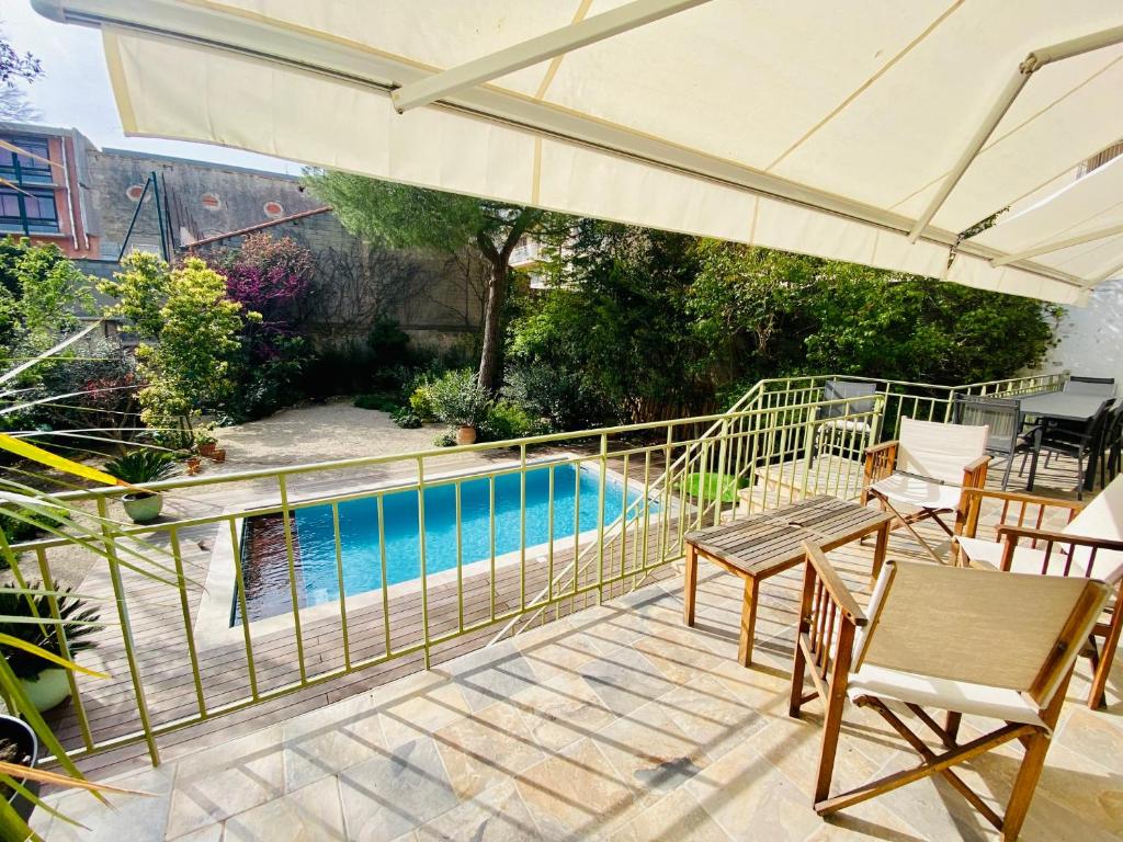 un patio avec un parasol et une piscine dans l'établissement ''Les Halles'' Maison de ville avec piscine et garage aux Halles, à Sète