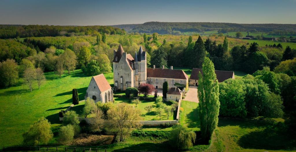 an old house on a green field with trees at Studio indépendant ,Manoir de la Vove,Perche in Corbon