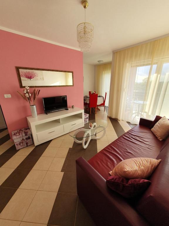 a living room with a couch and a pink wall at Lavanda Samarin in Zambratija