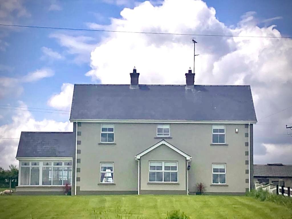a large white house with a green lawn at Corraglass House - close proximity to Cuilcagh in Letterbreen