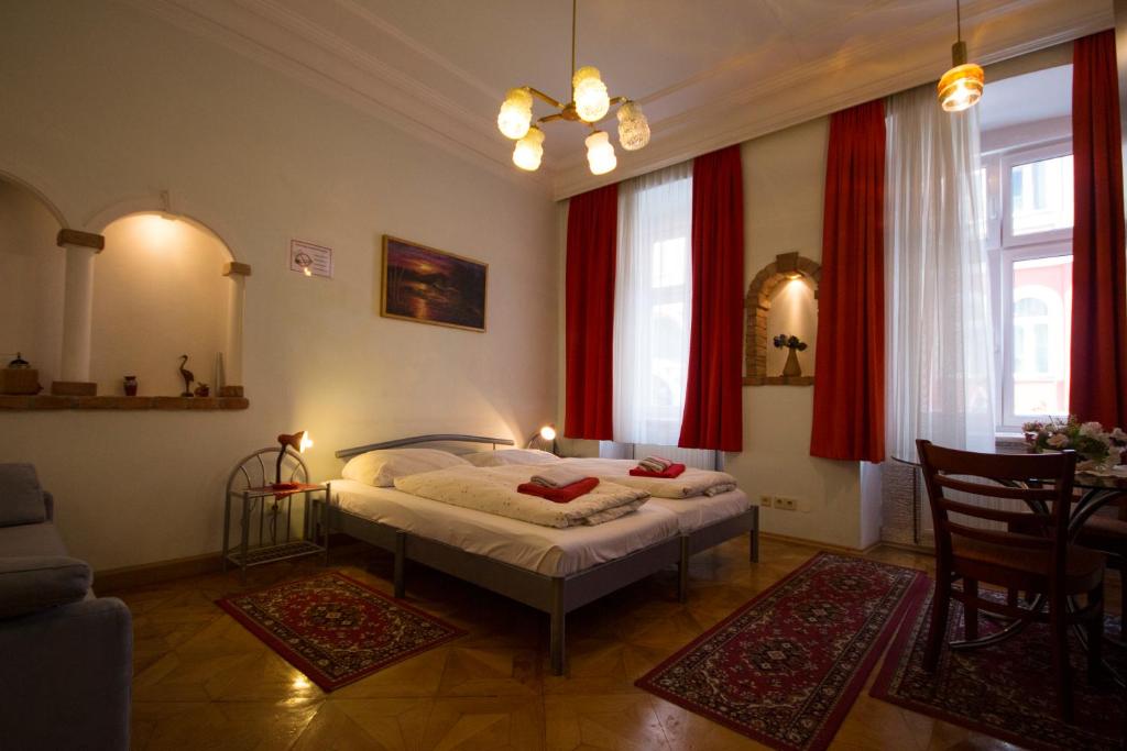 ウィーンにあるハッピーホステルの赤いカーテンが備わるベッドルーム1室です。