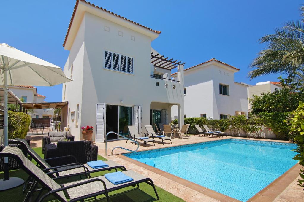 a villa with a swimming pool and a house at Villa Palm in Protaras