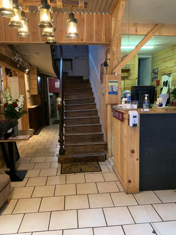 a stairway leading up to a restaurant with wooden stairs at Le Pourquoi pas in La Bourboule