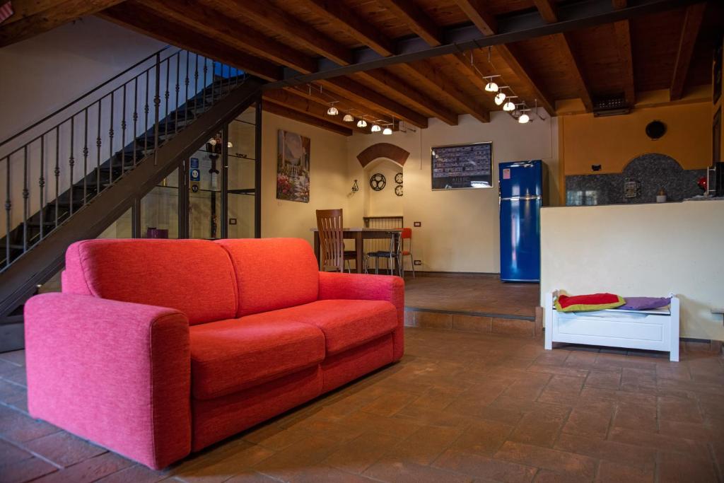 a living room with a red couch and a staircase at Casa Dolce Casa Alzaia Grande in Milan