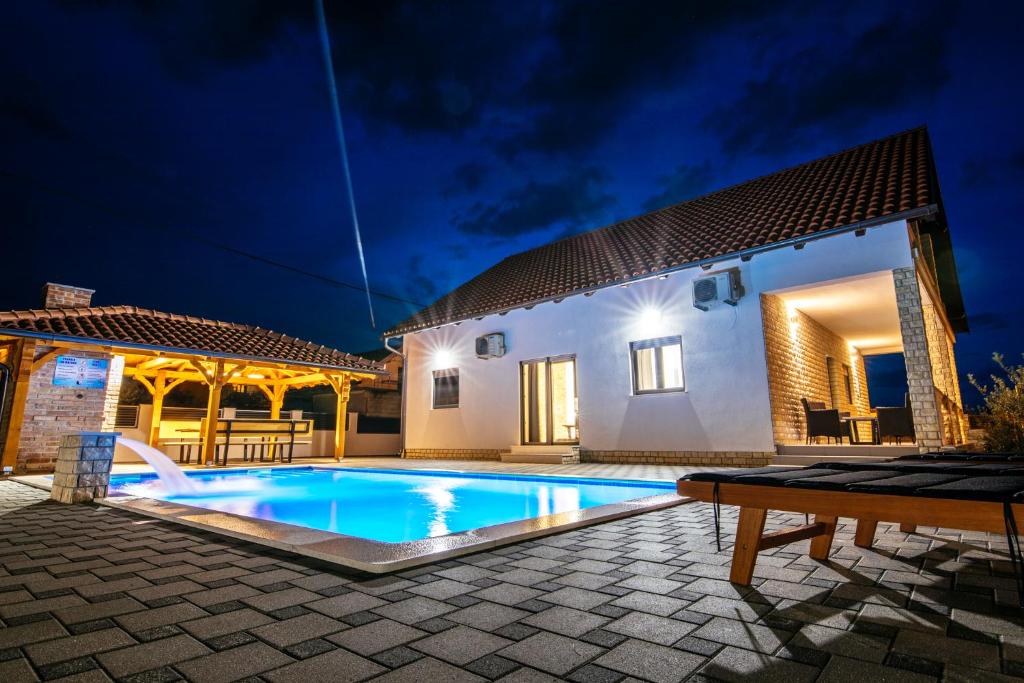 a villa with a swimming pool at night at Family house Moja jube in Oklaj