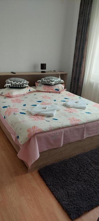 a bedroom with a bed with a flower bedspread at Pensiunea Happy Flowers in Greci