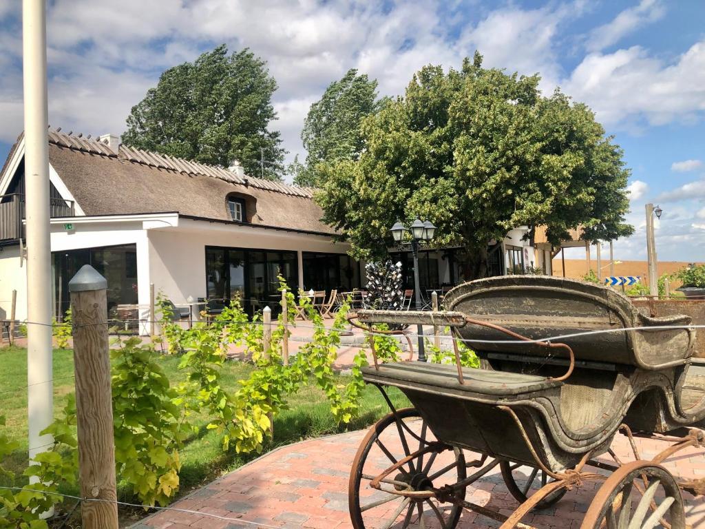 an old wheelbarrow sitting in front of a house at Sydkustens at Pillehill in Skivarp