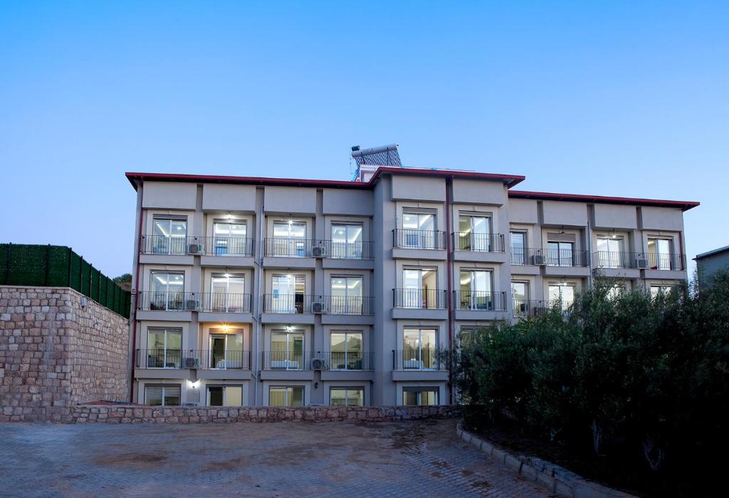 a large building with many windows on the side of it at İNDAĞ APART AİLE Oteli in Seferihisar