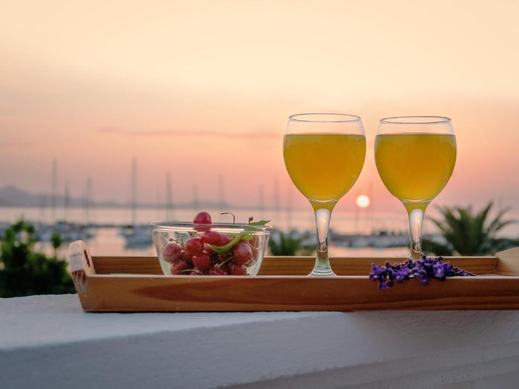 Dois copos de vinho e uma taça de fruta numa bandeja. em Apartments Vedmar em Bibinje