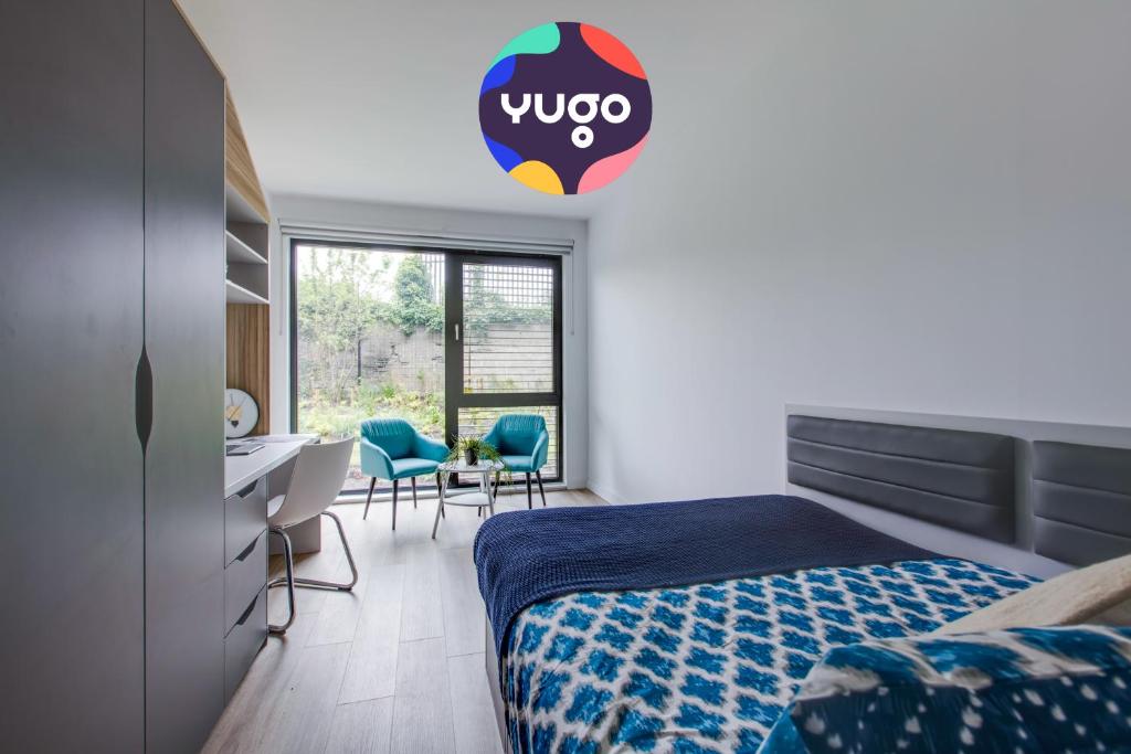 1 dormitorio con 1 cama, escritorio y sillas en Yugo Explore - Highfield Park, en Dublín