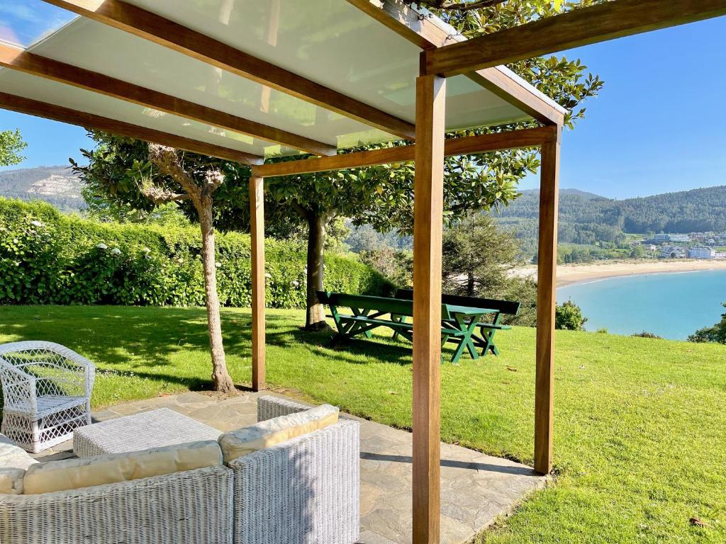 um pavilhão com uma mesa de piquenique e um banco em The Cliffs - Bungaleiro de Area em Viveiro