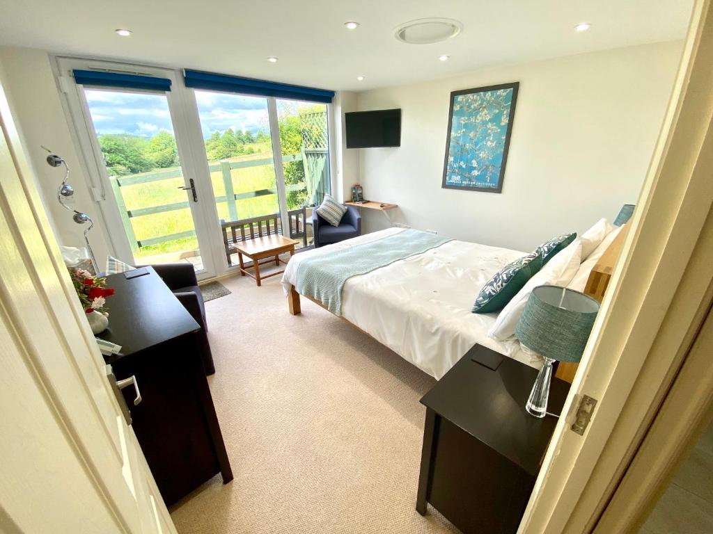 1 dormitorio con 1 cama y sala de estar en A secluded self contained Country Suite with a view - parking, easy access to Bath, en Corsham