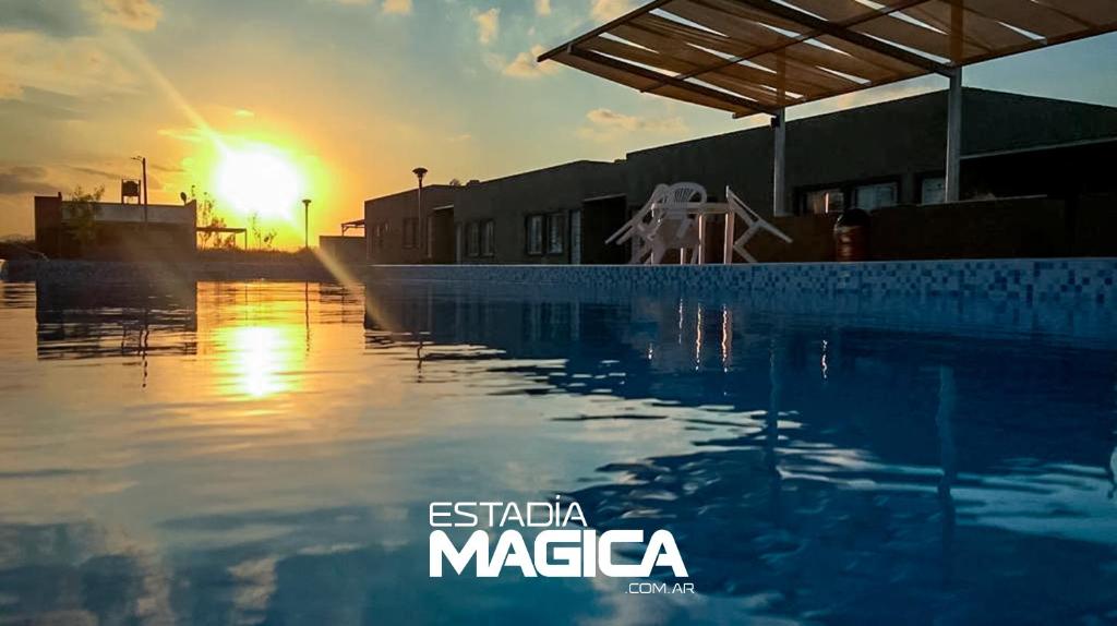 a sunset over a swimming pool with the words esica magica at Complejo Turístico Puelches in San Rafael