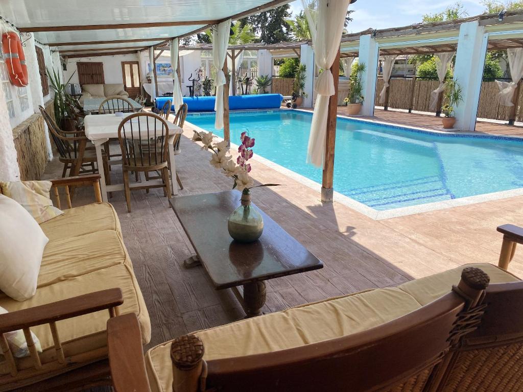 un soggiorno con piscina, tavolo e divano di 5 bedrooms house with private pool and furnished terrace at Torre Pacheco a Torre-Pacheco