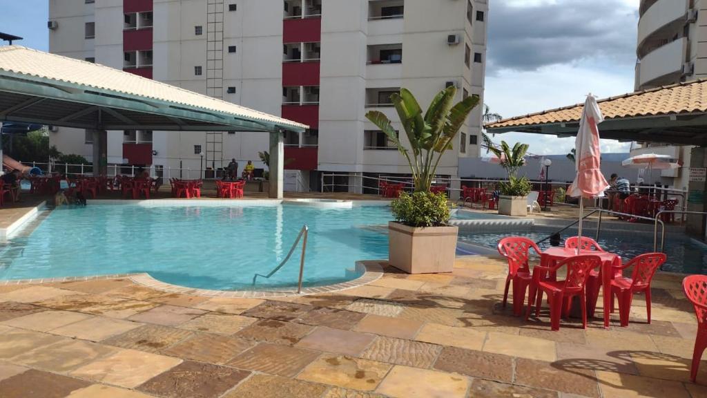 a swimming pool with red tables and chairs in a hotel at diRoma Fiore Hoteis Caldas Novas e os melhores Parques, Acqua Park, Splash, Slide in Caldas Novas