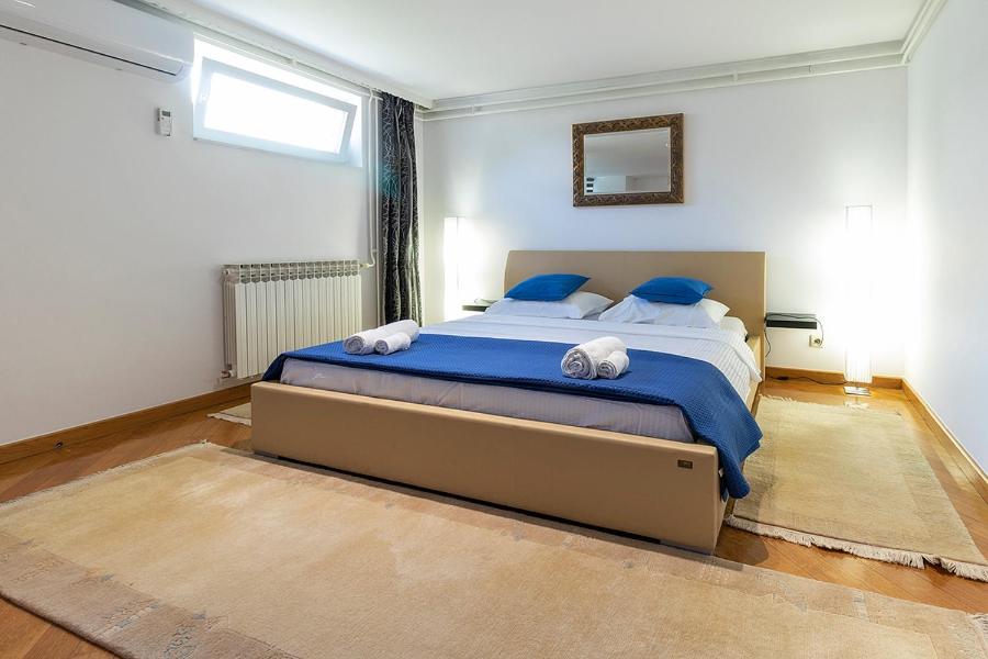 a bedroom with a large bed with blue sheets and blue pillows at Apartment Porin in Velika Gorica