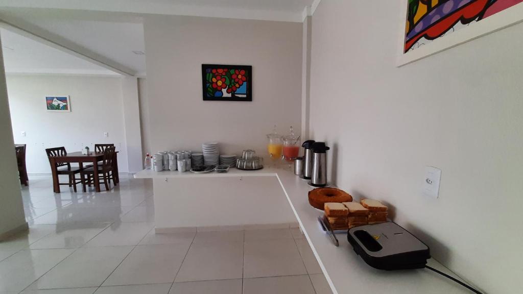 a white kitchen with a counter and a table at Pousada Brilho dos Lençóis in Barreirinhas