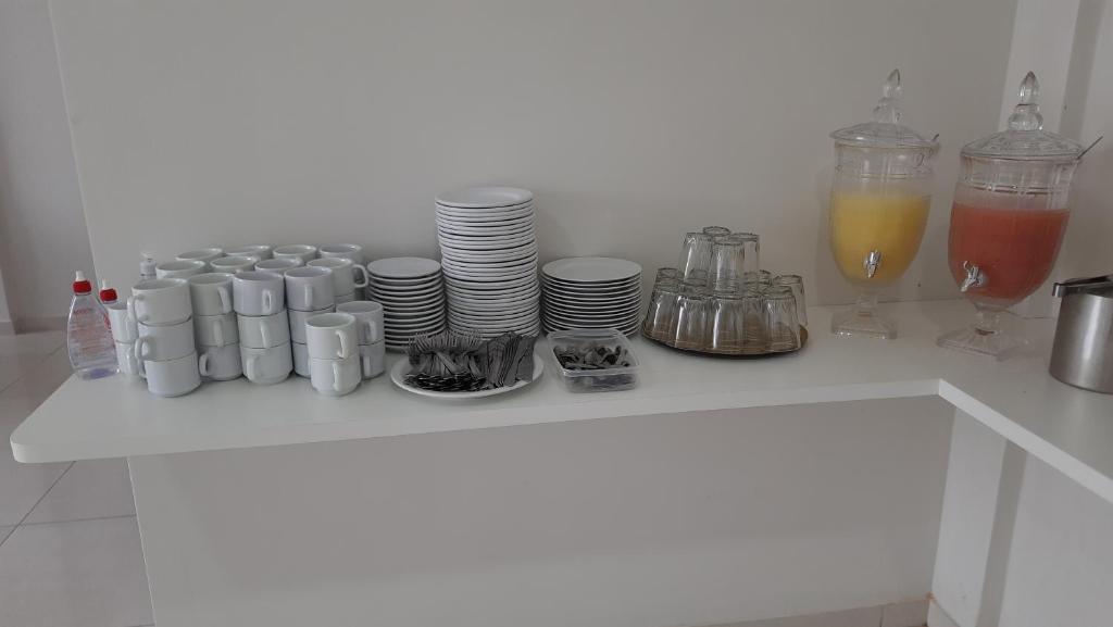 a table with cups and plates and drinks on it at Pousada Brilho dos Lençóis in Barreirinhas