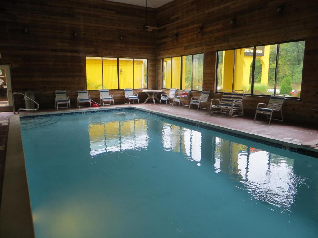 a large swimming pool with chairs in a building at Golden Manor Inn & Suites in Muldraugh