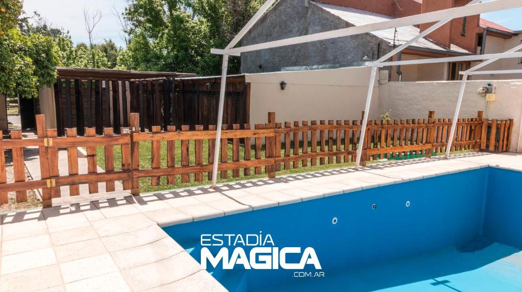 a fence and a swimming pool in front of a house at Quinta Montecaseros in San Rafael