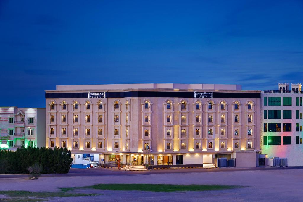 阿可賀巴的住宿－Staybridge Suites - Al Khobar City, an IHG Hotel，前面有灯的大建筑