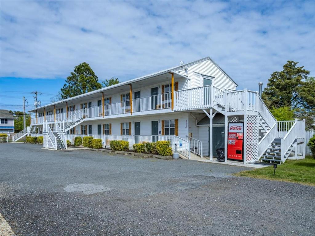 ein großes weißes Gebäude mit weißen Geländern in der Unterkunft Beach Bum West-O Motel in Ocean City