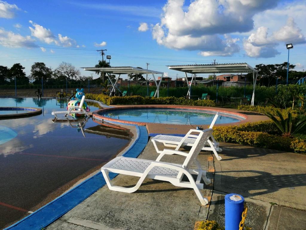 un par de sillas sentadas en una piscina con un avión en Tu Apartamento en el Eje Cafetero, en Montenegro