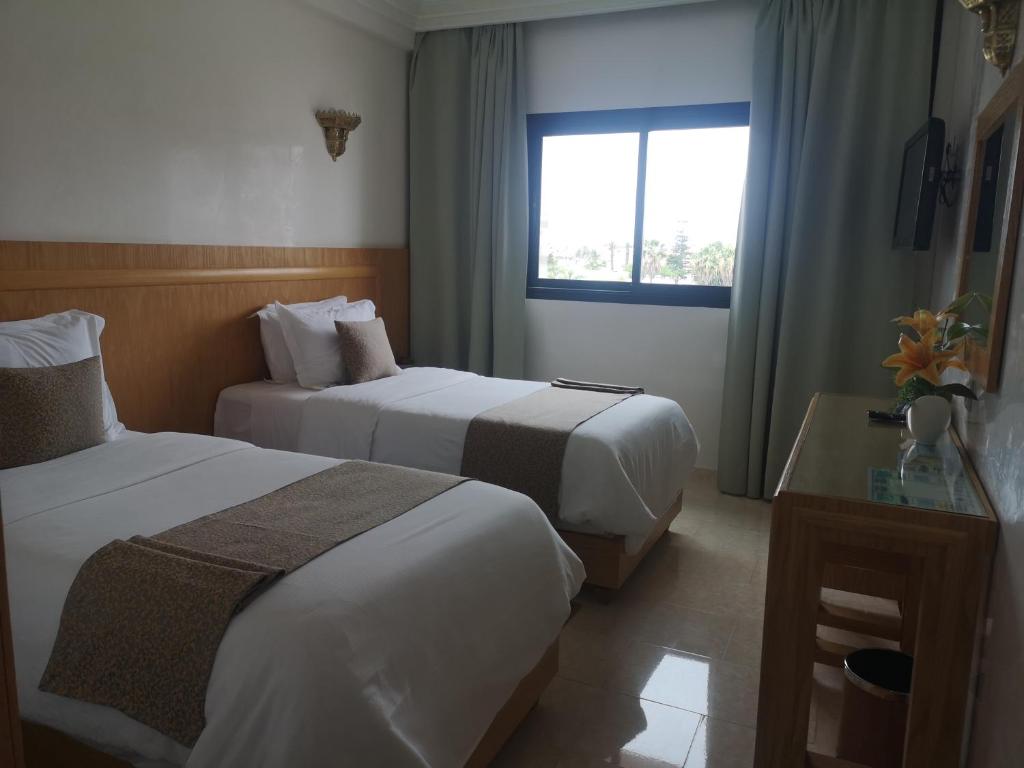 a hotel room with two beds and a window at Majliss Hotel Downtown in Rabat