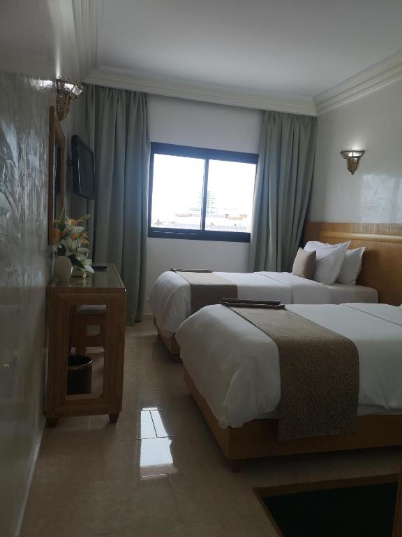 a hotel room with two beds and a window at Majliss Hotel Downtown in Rabat