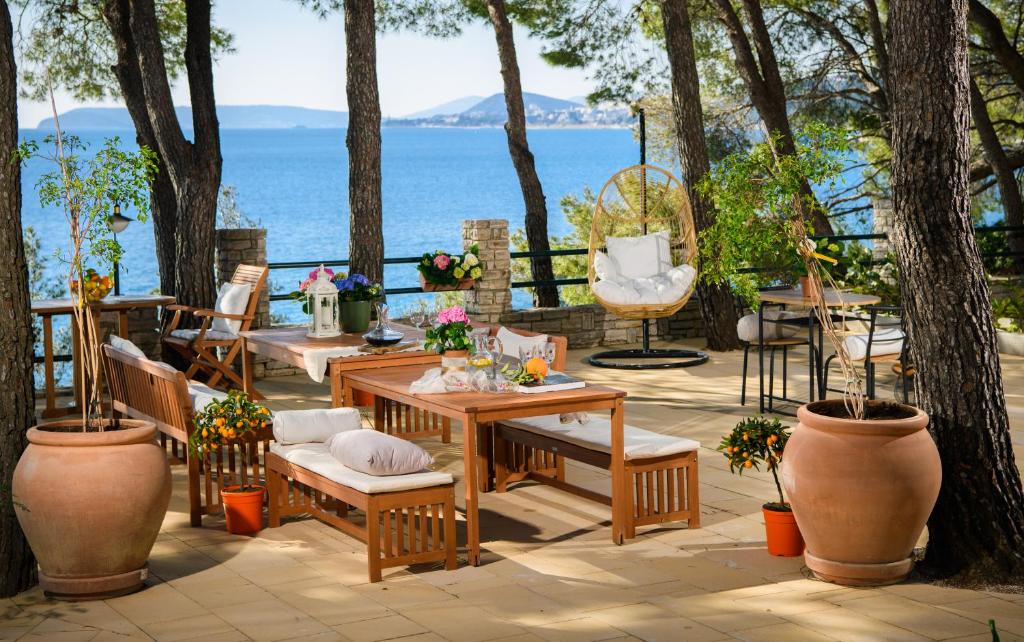 patio ze stołem i krzesłami oraz oceanem w obiekcie Lavica Bellevue apartments & studios w Podstranie