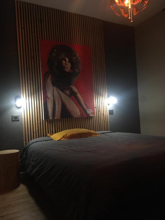 une chambre avec un lit avec un tableau sur le mur dans l'établissement Maison cosy à 2km du circuit bugatti des 24h, au Mans