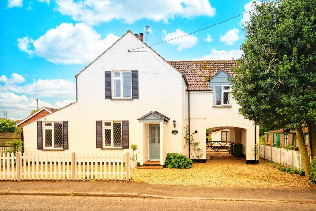 una casa blanca con una valla blanca en Norfolk Holiday Cottage 4-Bed Luxury Dog friendly, en Heacham